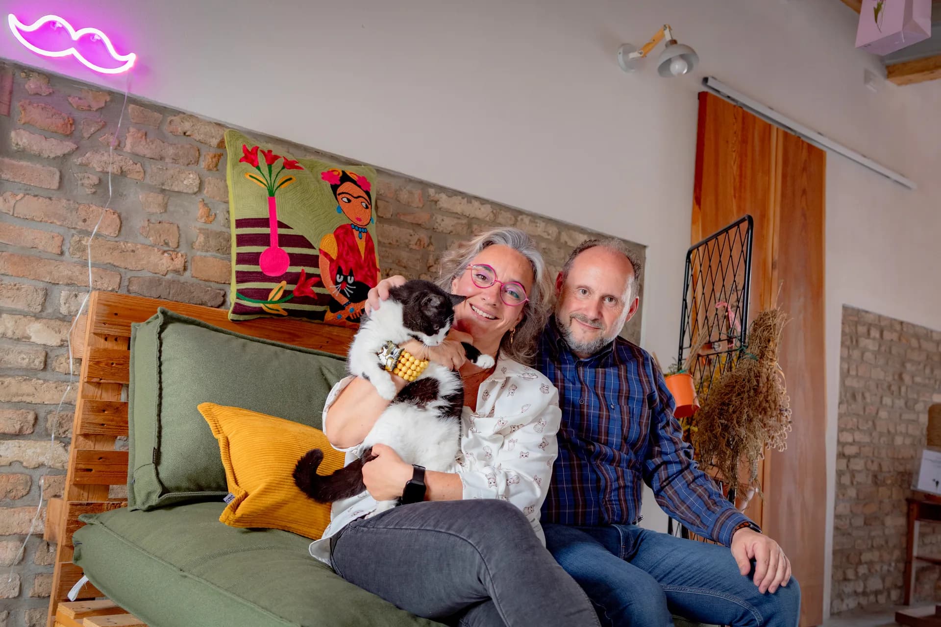 Alessandra e Alessandro con un gatto nella corte mantovana del B&B Zucchero sui Baffi